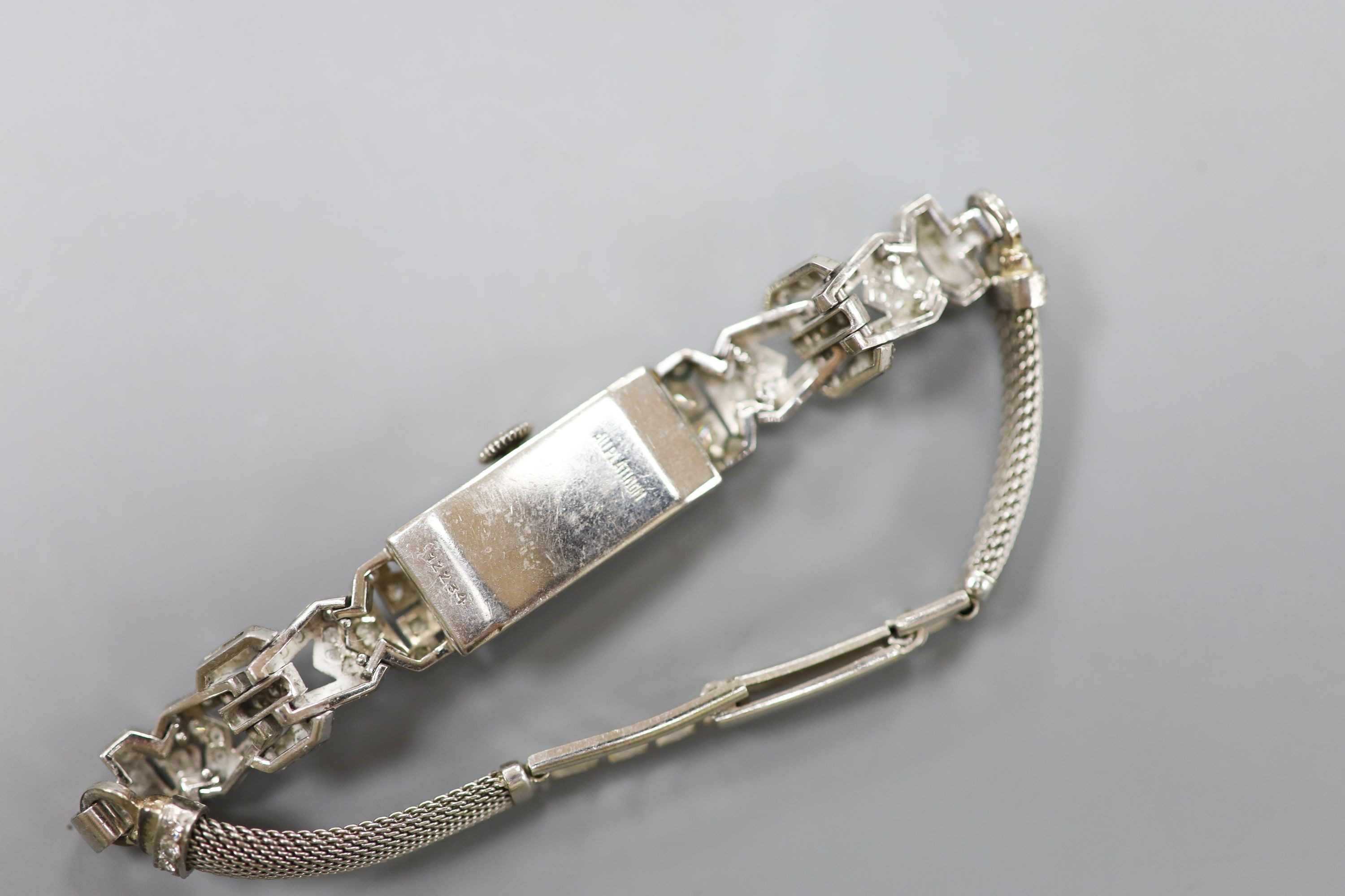 A white metal (stamped All platinum) and diamond set manual wind cocktail watch, on a 9ct white metal mesh bracelet, gross weight 21.6 grams.